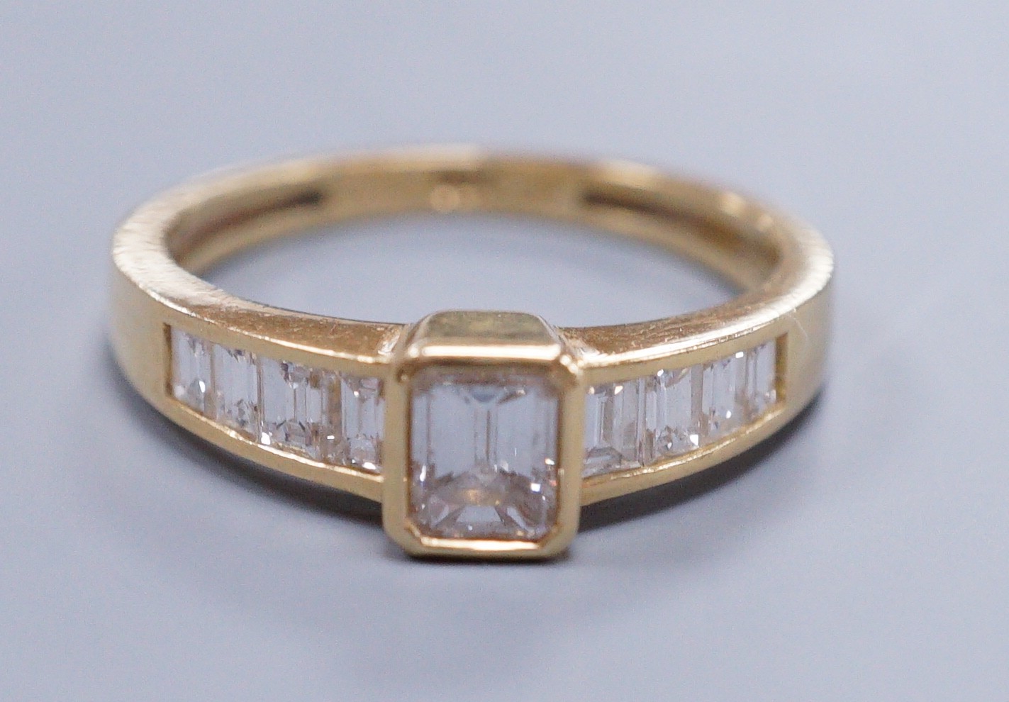 Am 18ct gold and diamond dress ring, with central octagonal cut stone and emerald cut shoulders, size O, gross weight 3.4 grams